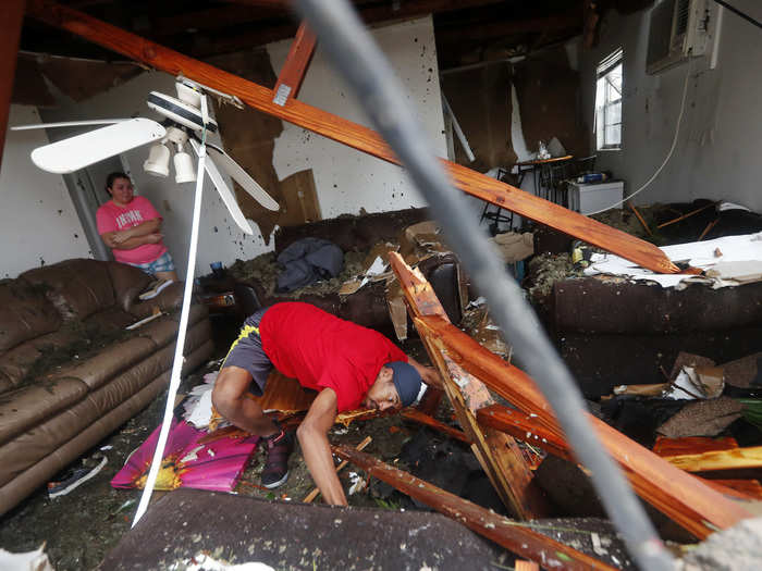 Dorian Carter looks under furniture for a missing cat after several trees fell on their home. Florida Gov. Rick Scott urged people to stay indoors. "Again, it is imperative for you to stay indoors as our first responders arrive. The roads need to be clear so they can respond as needed without inference," he said.