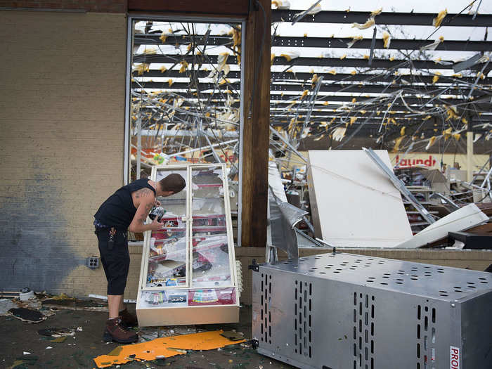 A man takes some tobacco products from a damaged store in Panama City on Wednesday.