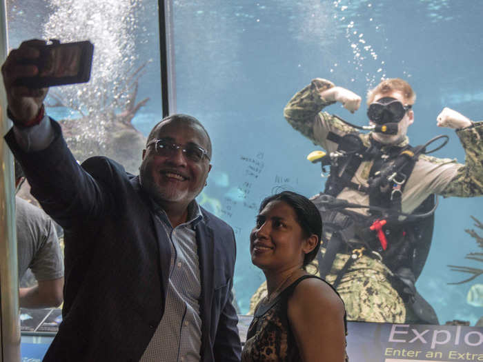 Navy Diver 2nd Class Trey Crane, assigned to Mobile Diving and Salvage Unit (MDSU) 2, poses for a selfie with visitors at the New York Aquarium during Fleet Week New York (FWNY) 2018 on May 23, 2018.