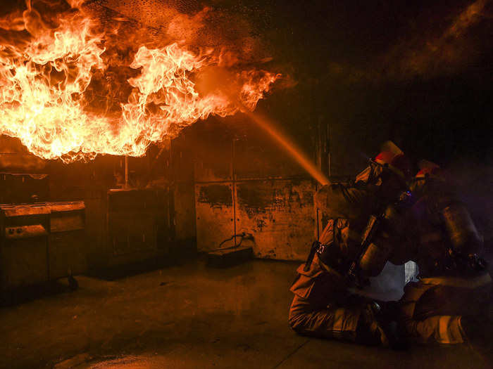 Sailors assigned to aircraft carrier USS Nimitz (CVN 68) and Arleigh Burke class destroyer USS Momsen (DDG 92) practice firefighting skills and techniques by battling a simulated fire at the Bremerton International Emergency Services Training Center on Mar. 22, 2018