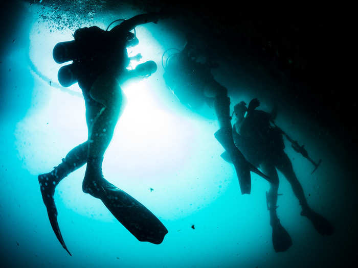 U.S. Navy Divers, assigned to Mobile Diving Salvage Unit (MDSU) 1, conduct an underwater pier survey with divers assigned to Underwater Construction Team (UCT) 2 in Apra Harbor on Dec. 14, 2017