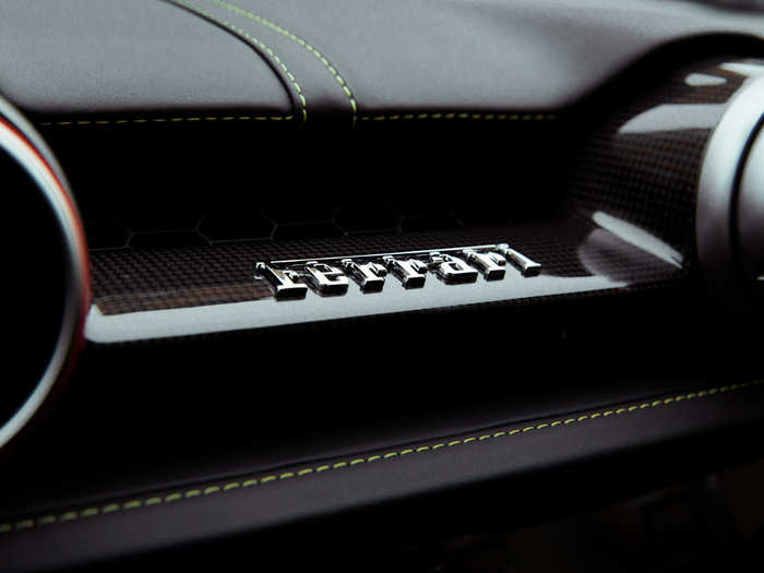 The Ferrari nameplate, a bit of metallic atop a surface of carbon fiber.