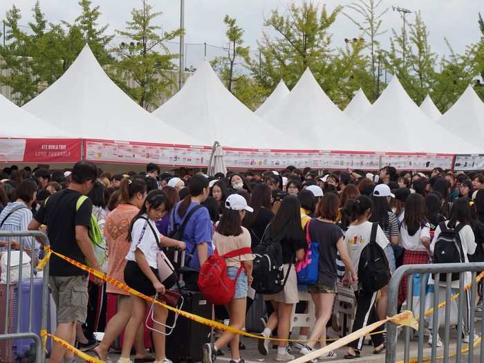 The lines for the official merchandise were insane. Organizers had to transform a parking lot into a massive makeshift camping site. I asked around. Some had been waiting since morning, others since up to two nights before. Many had suitcases.