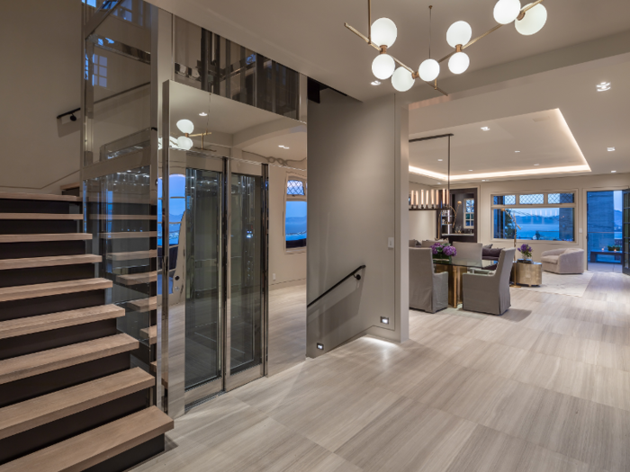 The home has four levels, all of which are connected by a glass elevator ...