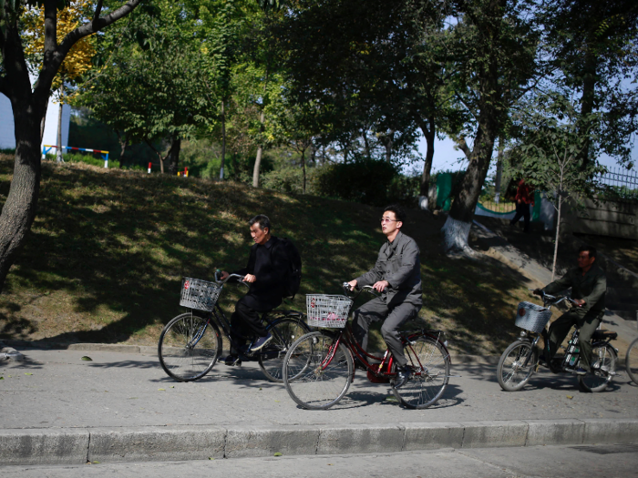 North Korean commuters can be easily spotted in their suits on bikes.