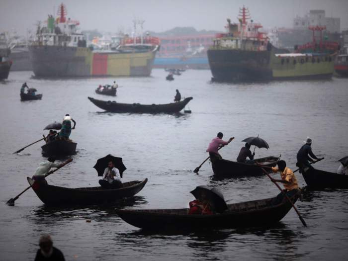 People in Bangladesh commute in boats similar to canoes — even in the rain.