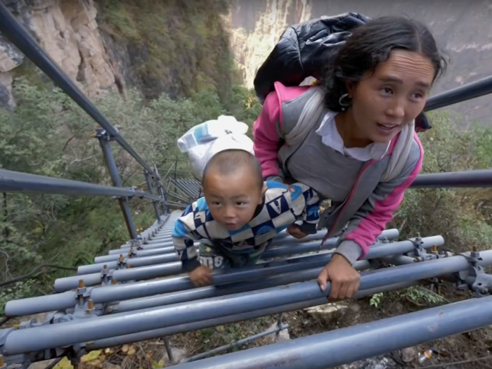 In Sichuan, China, 20 school children scale a giant steel ladder up an 800 meter, or 2,624-foot, plateau to get to class.