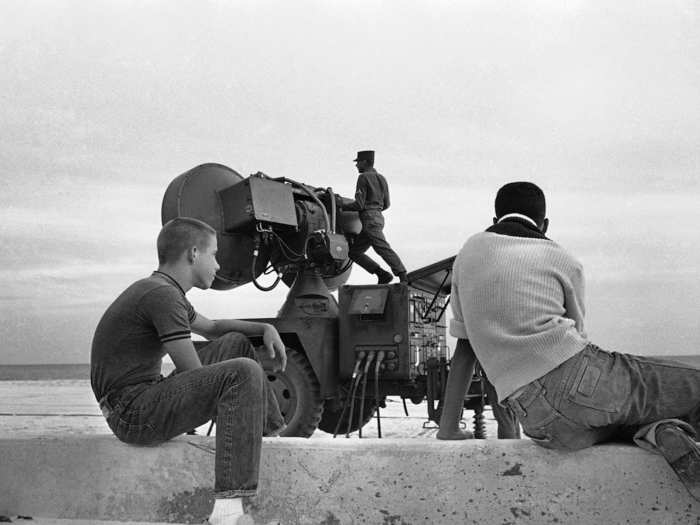 Two kids watch a US soldier make adjustments on anti-aircraft missile equipment set up on a public beach at Key West, Florida, October 26, 1962. The Army obtained permission from the City of Key West to use the beach for the installation.