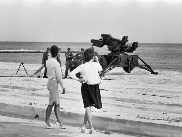 Two women watch US soldiers setting up anti-aircraft missile launchers on a beach in Key West, Florida, October 26, 1962. The Army took over a large section of public beach named after US Senator George A. Smathers.