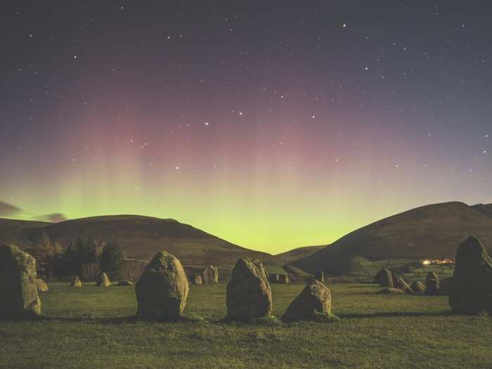 Auroras infrequently push into the UK, but when they do, a spectacular sight awaits. In this runner-up picture, moonlight illuminates a field while auroras in the background glow behind the hills.