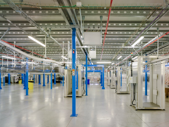 Boxes with newly sewn-together clothing are unpacked from trucks and immediately passed through a sensor machine.