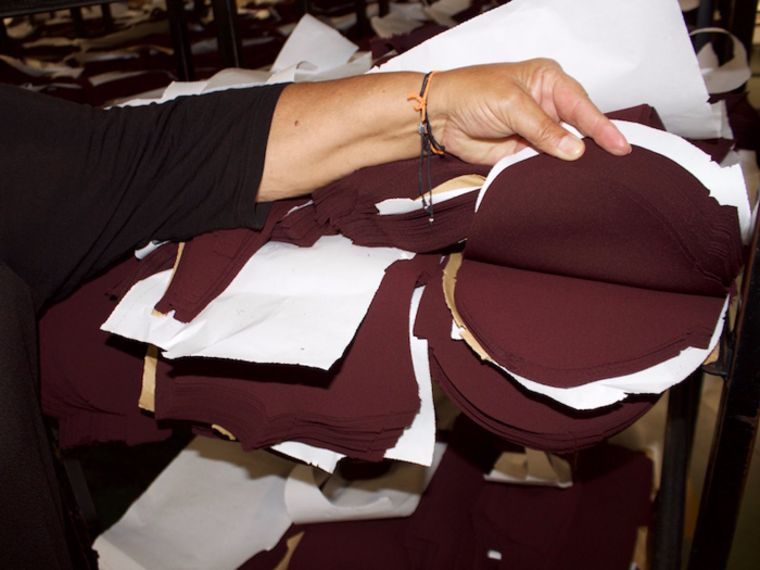 Once they have been cut, the paper and fabric pieces are boxed up together. The paper has all the details for the factory workers to see where these pieces need to be sent next, and which part of the garment they will make up.