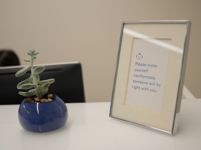 One wall was painted a deep, calming shade of blue, and small potted plants sat on white tables that looked like they were about to be outfitted with iPads.