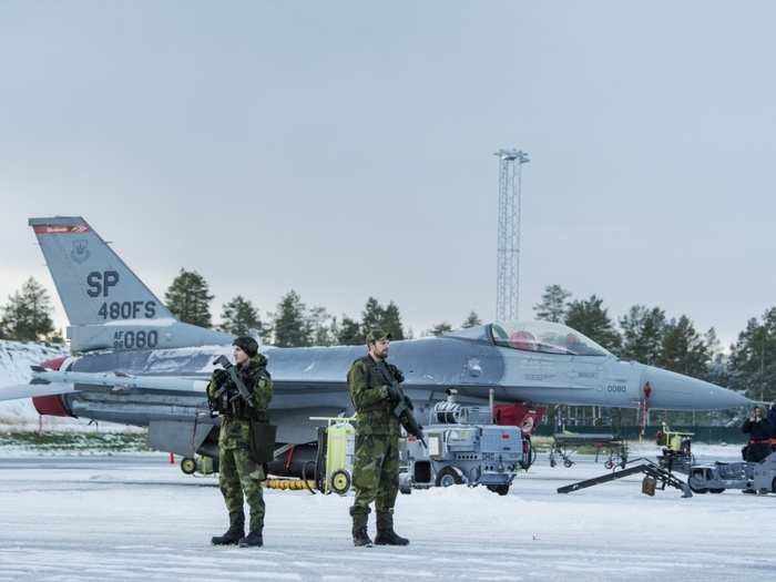 Swedish Air Force Pvt. Salem Mimic, left, and Pvt. Andreas Frojd, right, both with Counter Special Forces Platoon, provide security for US Air Force airmen and aircraft on the flight line at Kallax Air Base, Sweden, Oct. 26, 2018, during Exercise Trident Juncture 18.