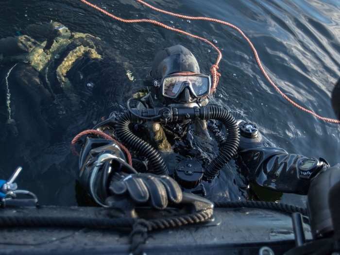 Divers from Royal Netherlands Navy mine hunter HNLMS Makkum dive on exercise mines October 27, 2018 as part of a drill in the fjords near Molde, Norway.