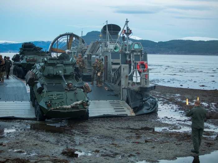 Marines with 24th Marine Expeditionary Unit offload their armored assault vehicles as they establish a beachhead.