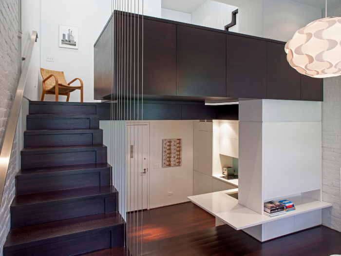 This loft on the Upper West Side features multi-level platforms with a small bathroom hidden beneath the stairs.