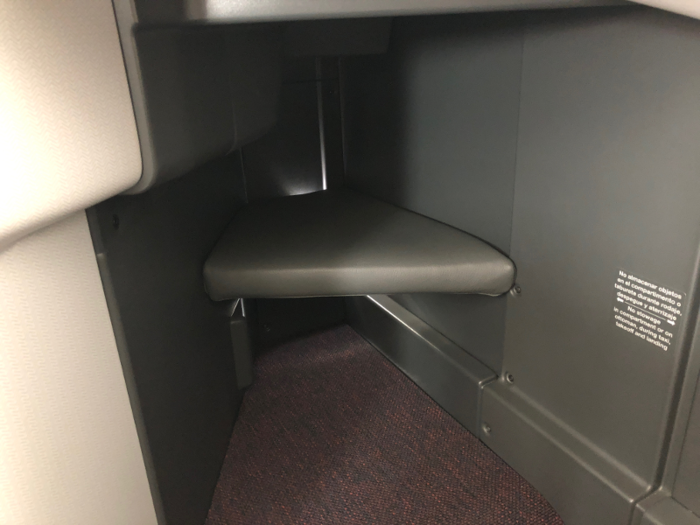 It’s always a little awkward to hold on to all that stuff while you wait to take off, but the reverse-herringbone business class seats had plenty of storage room — I stuffed mine into the roomy foot cubby (when you recline your seat, your feet go onto the ottoman).