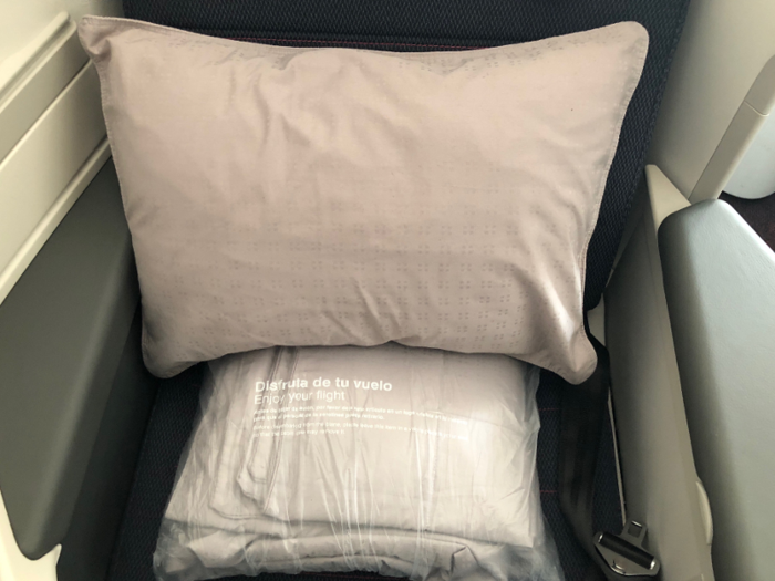 Each seat had a plastic-wrapped pillow and blanket waiting on it, as well as a pair of headphones on the storage area. Most business class flights also feature an amenity kit — however, the JFK–MEX route is too short and consequently has a few service items cut from the traditional international business class offerings.