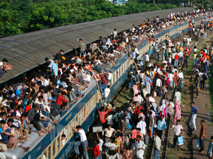 Some people use ladders to get onto the trains, some climb using the windows as leverage, and some get hoisted up by other riders.