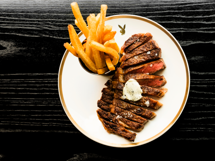 Some of the dishes served at the club include a Wagyu ribeye steak frites with truffle butter ...