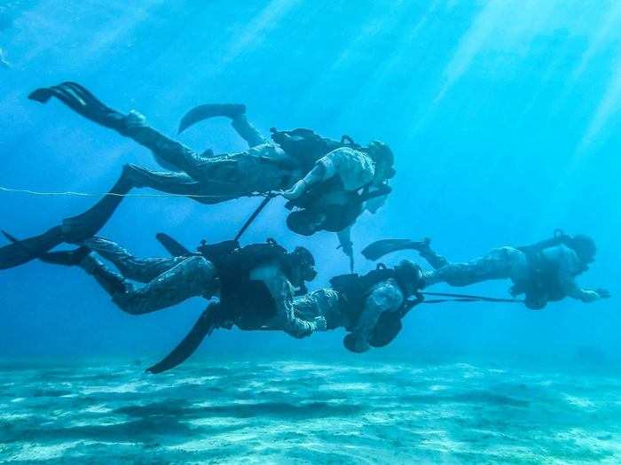 Marines with Maritime Raid Force, 26th Marine Expeditionary Unit swim under water during dive training in Aqaba, Jordan on July 8, 2018.