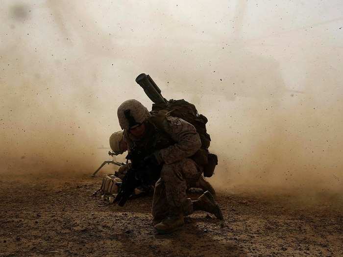 Cpl. Daniel Hopping, Assaultman, Weapons Company, 1st Battalion, 7th Marine Regiment, and a native of Rogers, Arkansas, shields himself from dust being kicked up from a CH-53E Super Sea Stallion lifting off during a mission in Helmand province, Afghanistan on April 28, 2014.