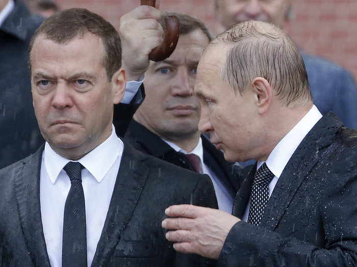 Prime Minister Dmitry Medvedev stands in the rain next to Putin during the same wreath-laying ceremony marking the anniversary of the Nazi German invasion.