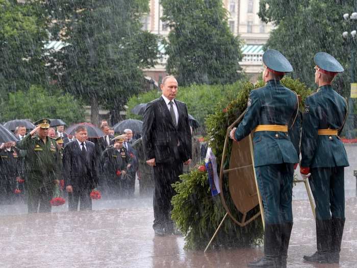 Russian President Vladimir Putin stands in the rain during a wreath-laying ceremony marking the anniversary of the Nazi German invasion in 1941.