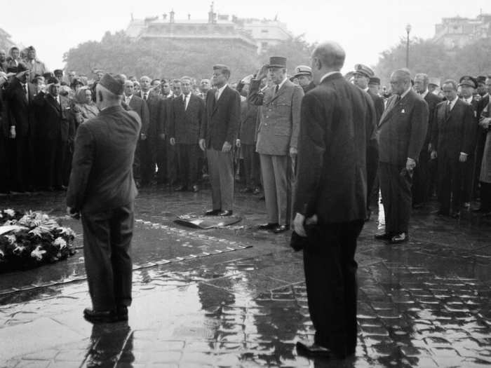 President John F. Kennedy and French President Charles DeGaulle stand in the pouring rain at Paris