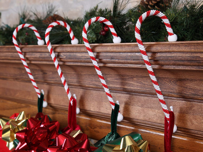 Candy cane-inspired stocking holders for a festive fireplace