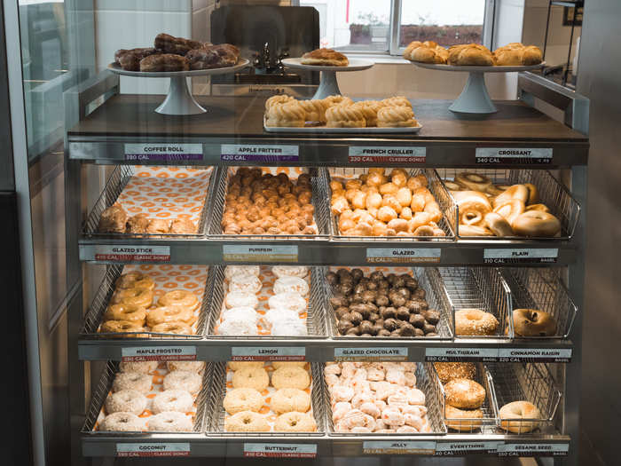 The bakery cases have doughnuts, munchkins, bagels, and other pastries.