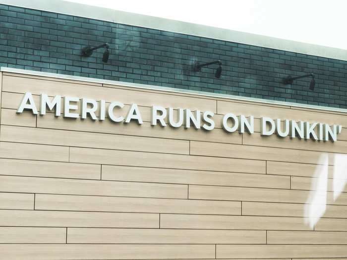 The outside of the store has a sign that reads "America Runs on Dunkin