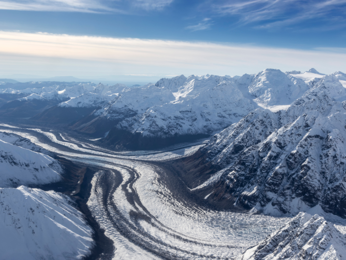 The helicopter passes by the Great Gorge — which would be nearly twice as deep as the Grand Canyon if the thousands of feet of ice melted — and crosses over crevassed ice fields before reaching the chalet.