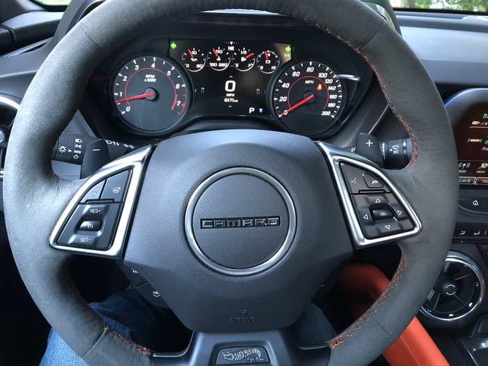 The steering wheel is suede, with orange topstitching and paddle shifters for manual mode.