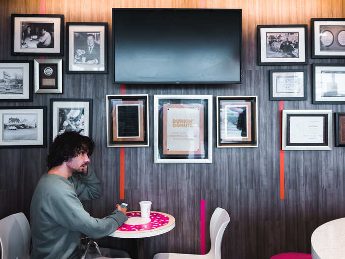 There are only two small tables in the back of the store. Hanging on the wall are framed photos and documents from when the store first opened, before it was remodeled to look like most other Dunkin