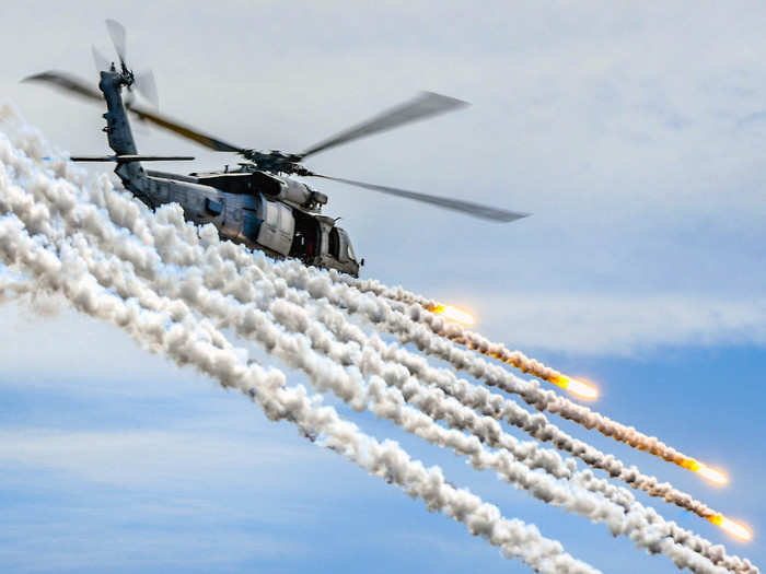 A Navy MH-60S Seahawk fires flares during an air power demonstration over the aircraft carrier USS Theodore Roosevelt in the Pacific Ocean on May 3, 2018.