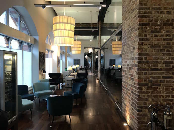 The first floor is sleek and stylish, with glass, exposed brick, and blues and greys.