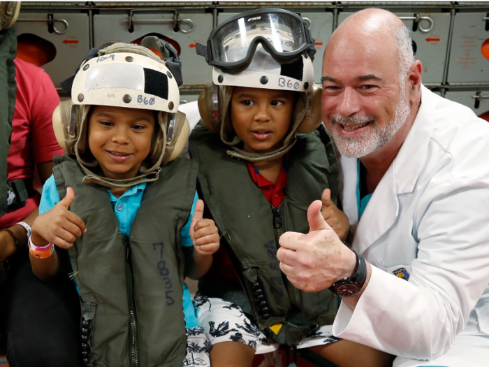 Patients are outfitted with helmets and inflatable life preservers before heading out to the ship