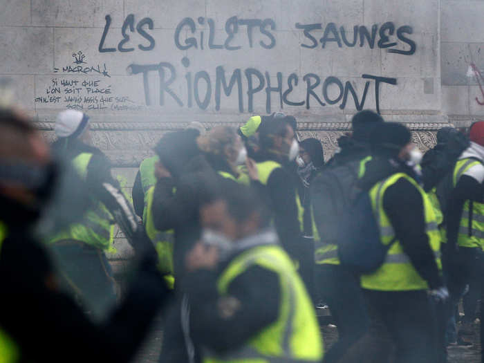 Graffiti that says "the yellow vests will triumph" and disparages President Macron was scrawled on monuments like the Arc de Triomphe.