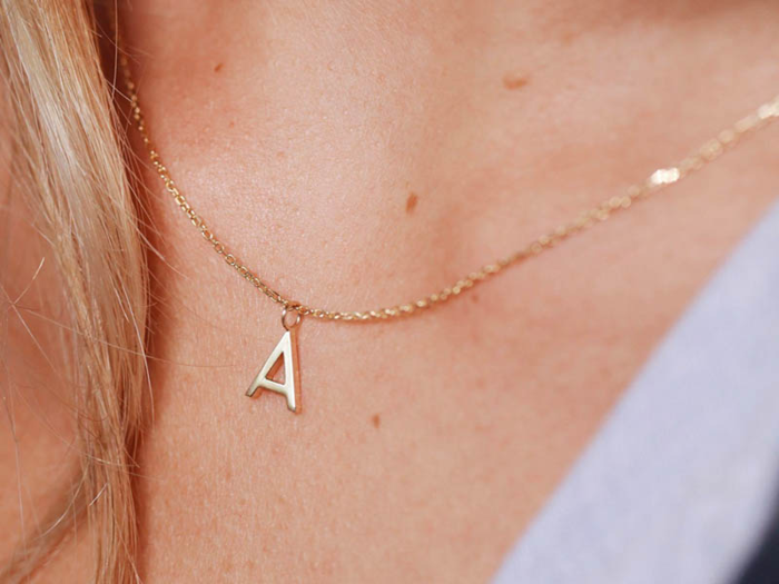 A gold letter charm from an ethical jewelry startup