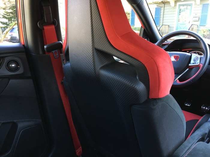 However, the carbon fiber seat backs and red seat belts look really cool.