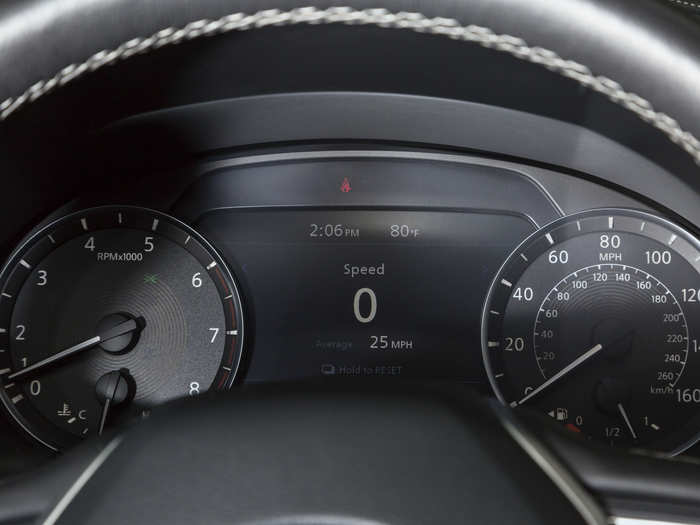 Beyond the steering wheel is a pair of concise analog gauges flanking a digital information display.