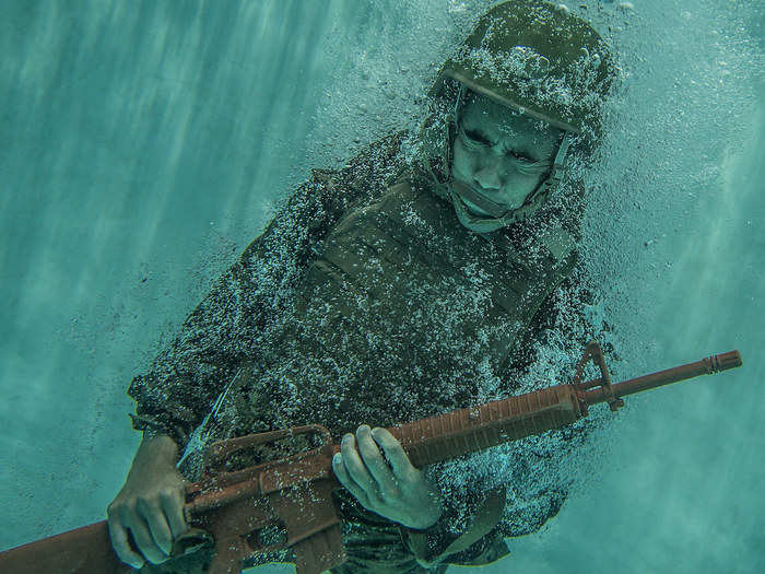 Marine Cpl. Randy Soliz dives into the water to shed his gear during an intermediate swim qualification on June 13, 2018.