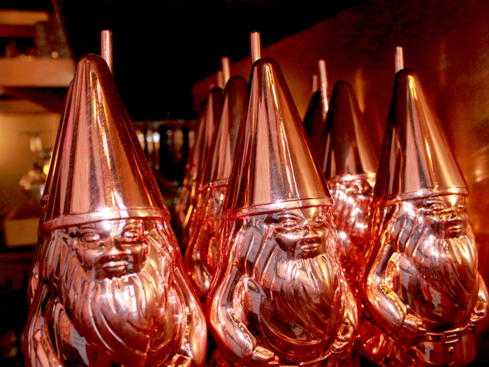 A cocktail called "Les Gnomes," made with Absolut Elyx vodka, Singani 63, Ancho Reyes, ginger syrup, and lemon juice, is apparently served in these whimsical gnome-shaped tankards.