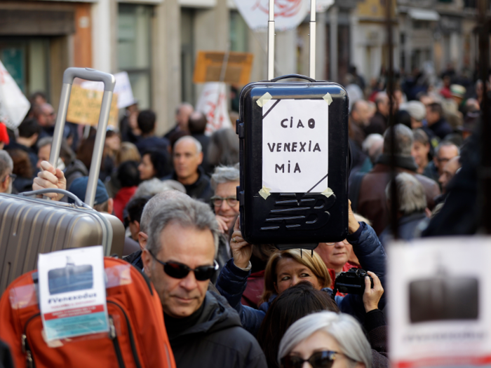 In this photo, a protester holds a sign reading "Goodbye My Venice."