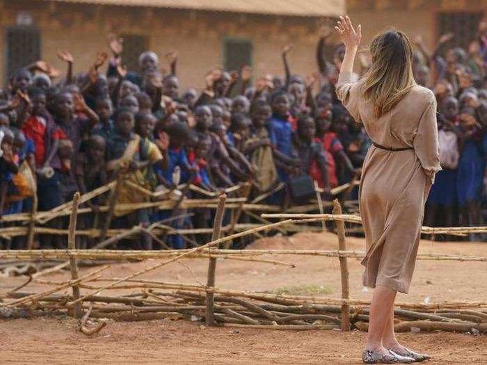 First lady Melania Trump waves to children and others as she visits Chipala Primary School in Malawi during her first big solo international trip.