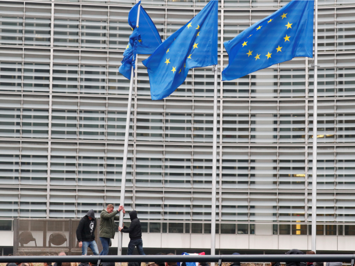 But the protests soon began to turn ugly. Here demonstrators are trying to topple an EU flag outside the European Commission headquarters.