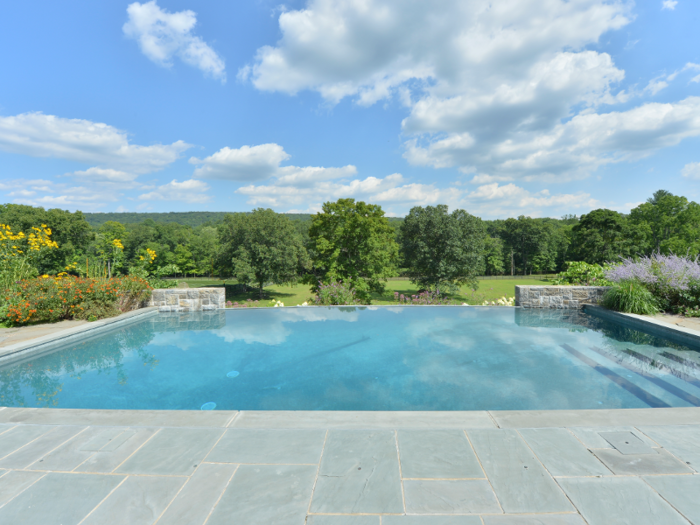 An outdoor infinity pool overlooks the expansive property.