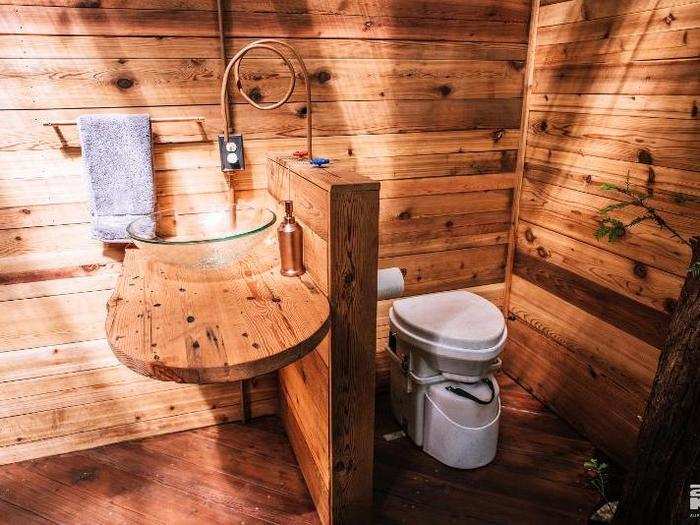 The bathroom includes a hot shower, composting toilet, and sink.